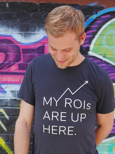 A male person with "My ROIs Are Up Here Tee" T-shirt